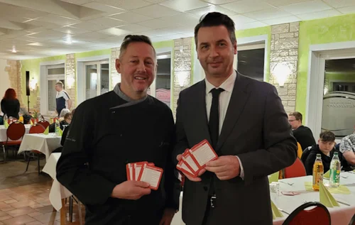 Bürgermeister Jörg Zietemann und John Schach (v.r.), Geschäftsführer des Havelrestaurants Schwedendamm in Rathenow und stellvertretender Vorsitzender des Dehoga-Kreisverbands Havelland, präsentieren die neuen Veranstaltungsbierdeckel der Stadt Rathenow.