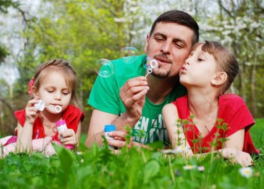 Familie mit Seifenblasen im Gras