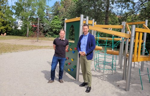 Bürgermeister Jörg Zietemann und der für Spielplätze zuständige Mitarbeiter der Stadt Stefan Main vor der neuen Spielgerätekombination auf dem Spielplatz in der Paul-Singer-Straße