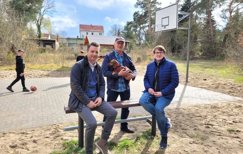 Bürgermeister Jörg Zietemann, Andreas Kubale und Ortsvorsteher Corrado Gursch am Rande der aufgewerteten Jugendspielfläche am Steckelsdorfer See