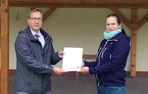 Alexander Goldmann, Amtsleiter für Wirtschaft und Finanzen über gibt den Zuwendungsbescheid an Susan Petrat, Vorsitzende des Fördervereins Dorfgemeinschaft Böhne e. V.