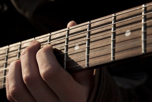Hand spielt auf Gitarre