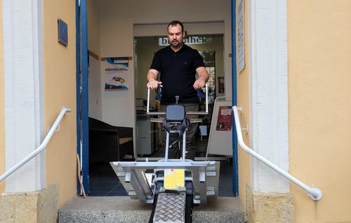 Bibliotheksmitarbeiter Stefan Nitsche demonstriert die Treppenraupe.