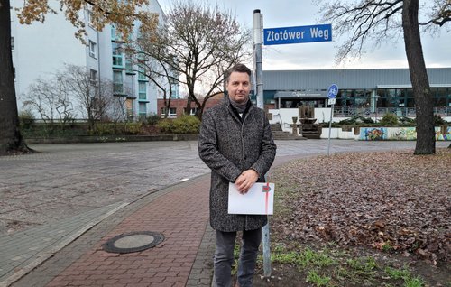Bürgermeister Jörg Zietemann vor dem neuen Straßenschild des Złotówer Weges 