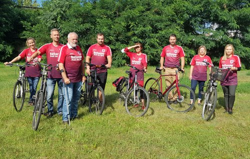 Mitarbeiter des Rathauses mit Fahrrädern und Teamshirts