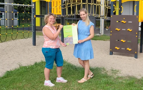 v.l.: Kitaleiterin Sina Köhler und die für die Organisation des Festes verantwortliche Erzieherin Marina Köhne mit dem Plakat zum Fest