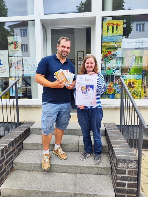 Stefan Nitsche von der Stadtbibliothek und Cornelia Scheide vom Bündnis für Familie präsentieren das Plakat zur Lesung 